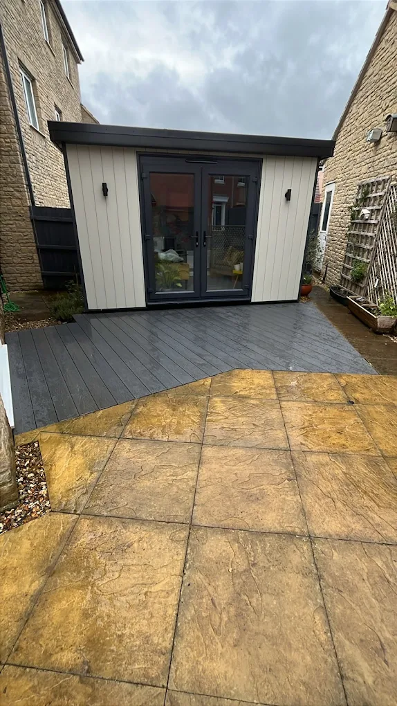 Garden room set on composite decking beside a new flagstone patio