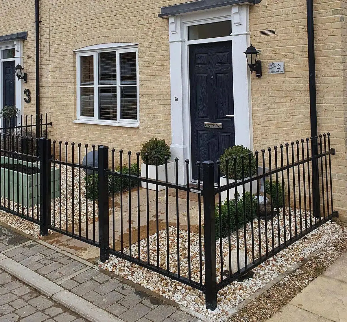 Black ball top railings around a gravelled front garden