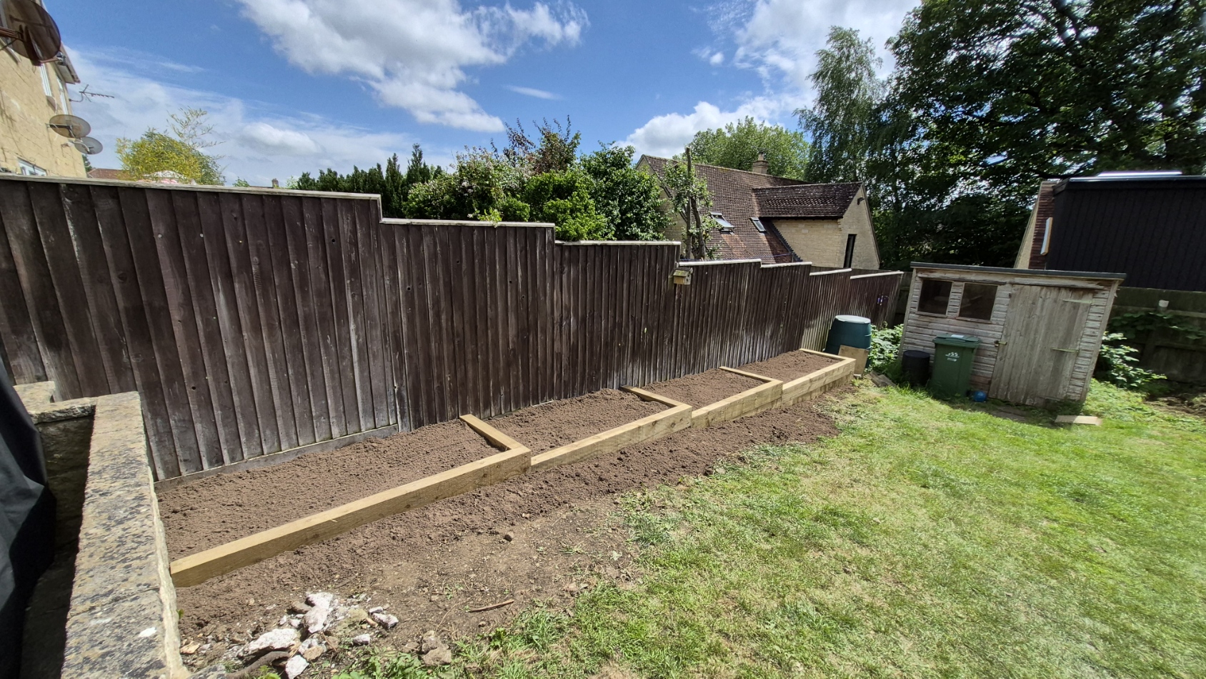 Long sleeper border built and filled along an existing fence line