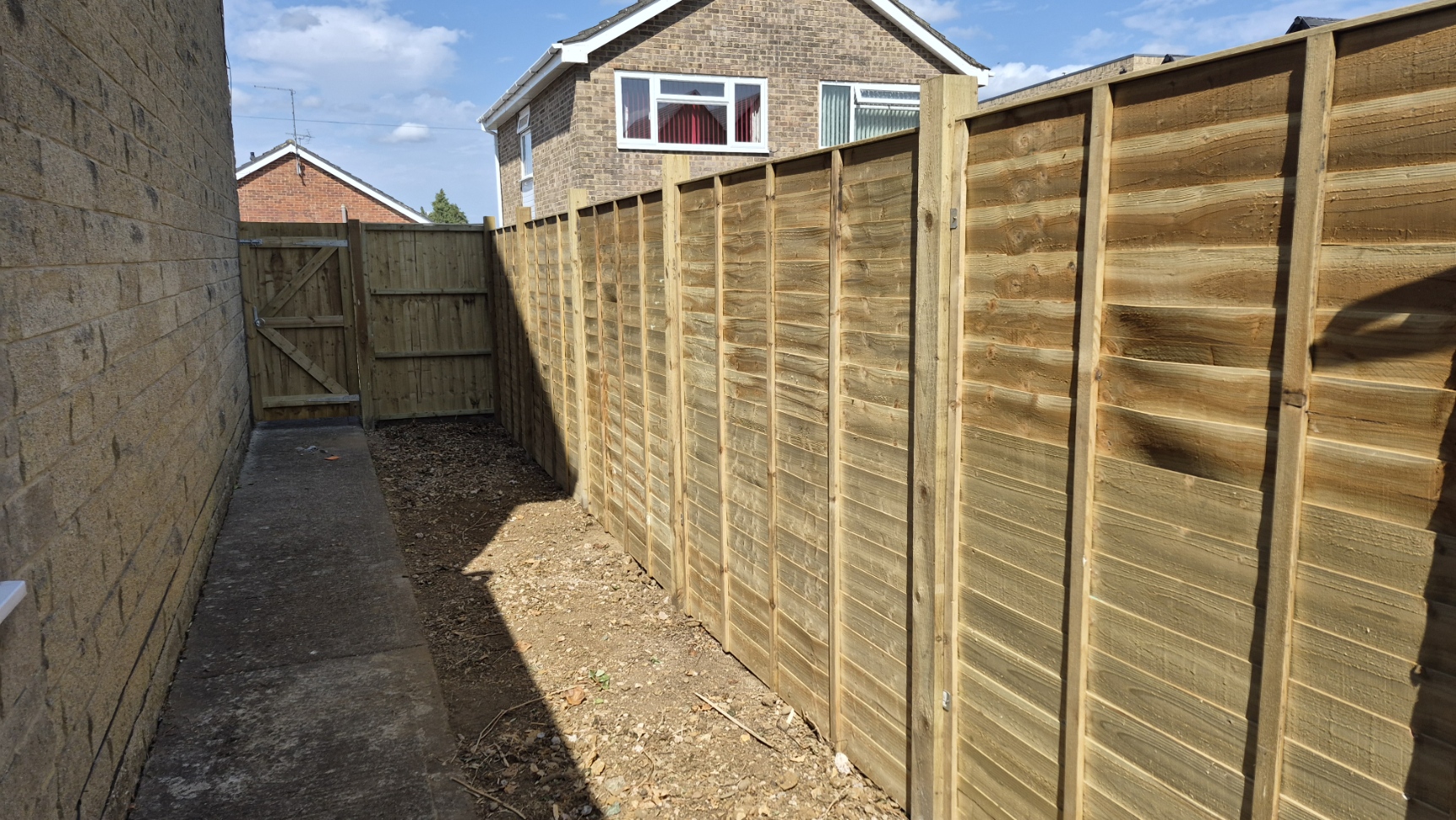 Side passage cleared and re-fenced with new panels and a gate