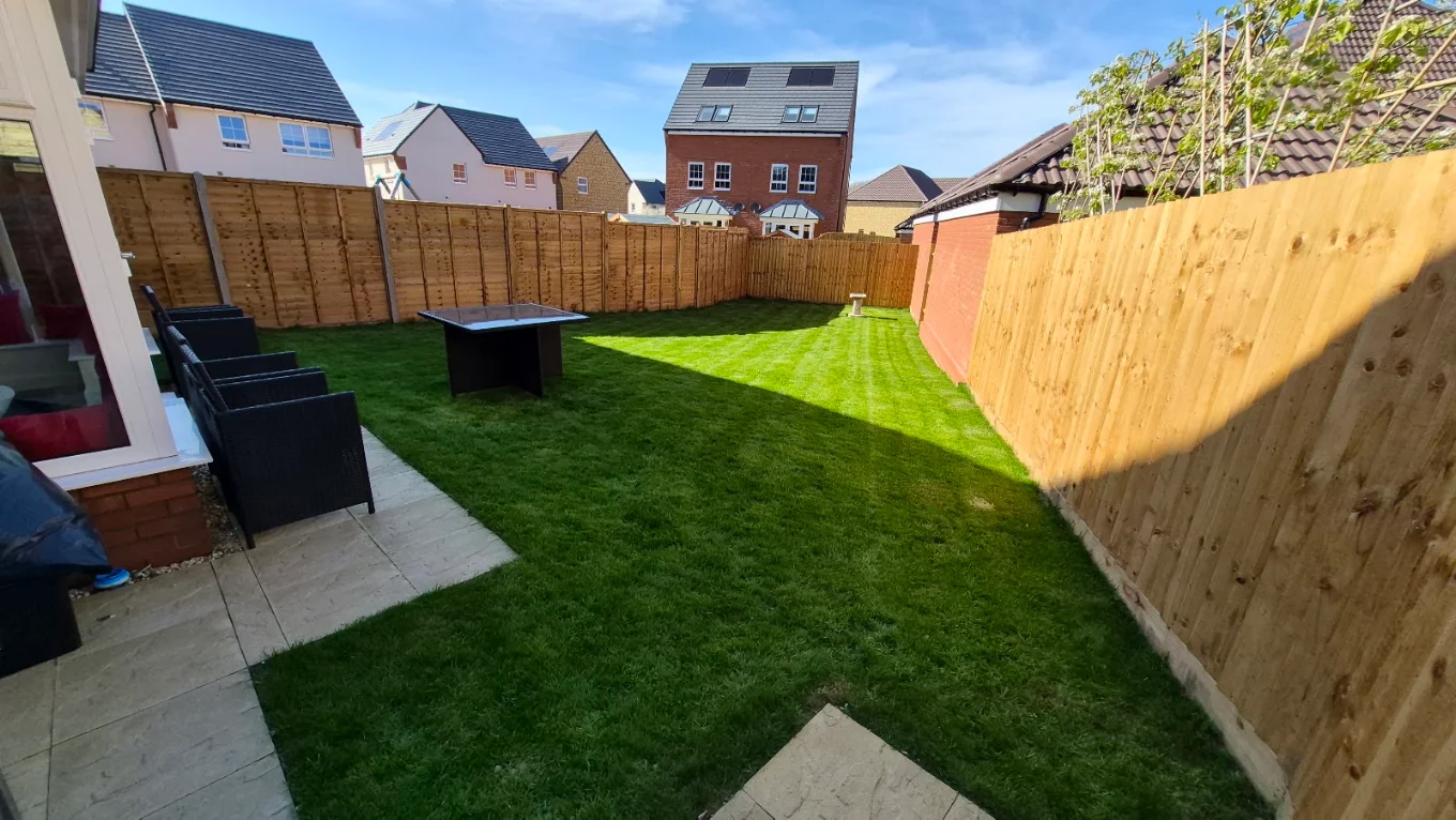 Freshly laid lawn and new fencing around a rear garden with patio seating