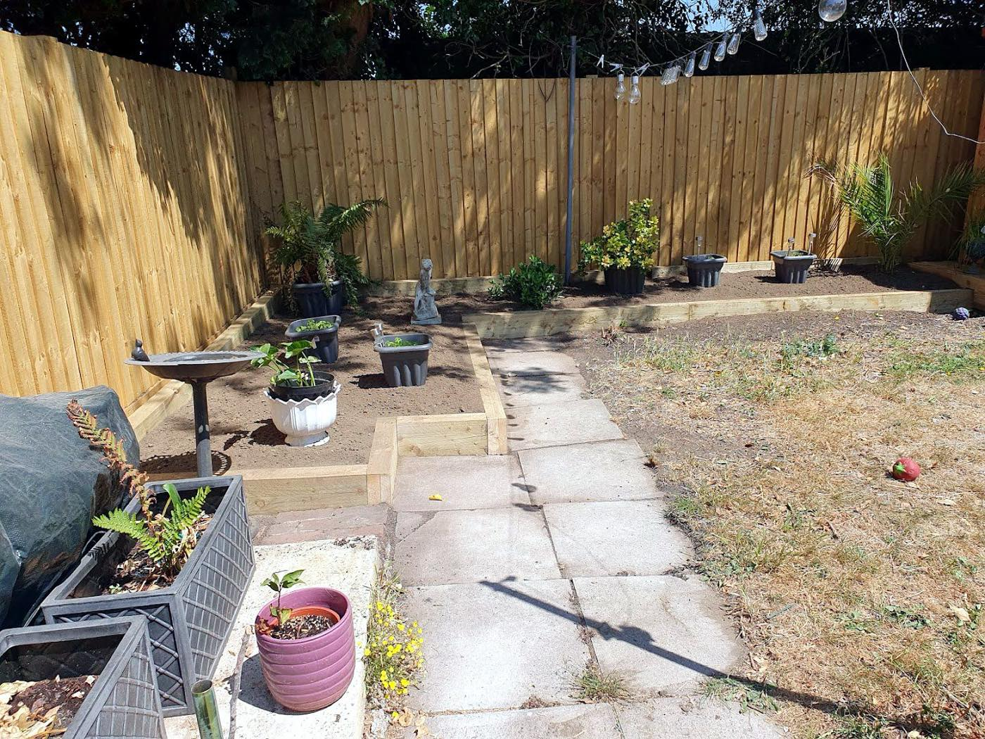 Sleeper raised beds and a paved path along new fencing