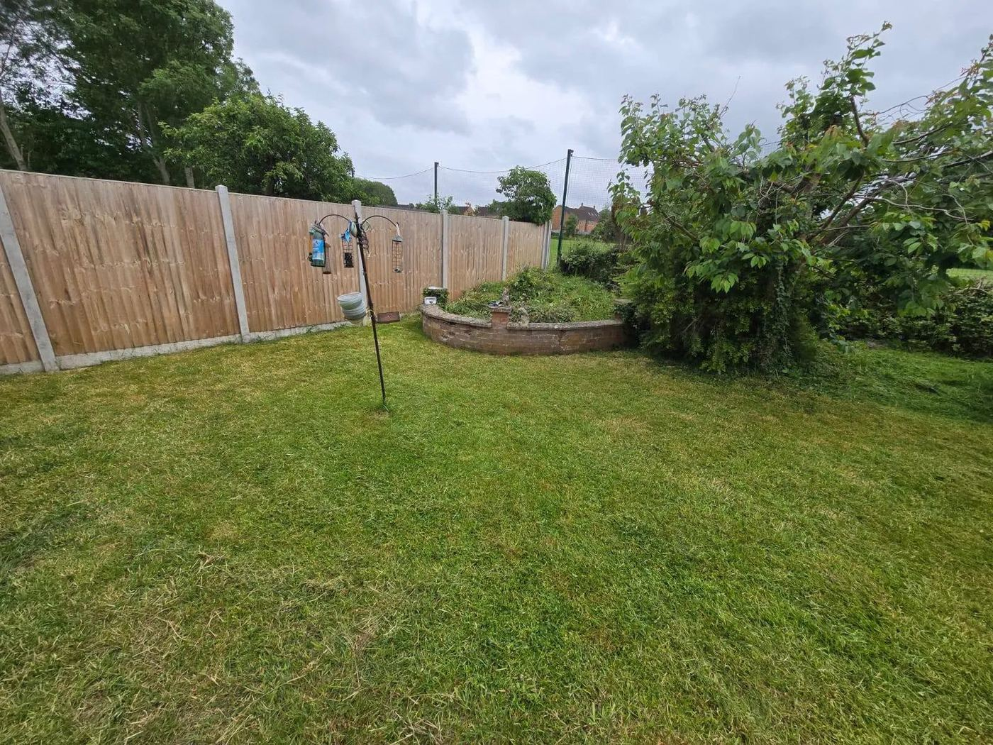 New feather edge panels and concrete posts around a lawn