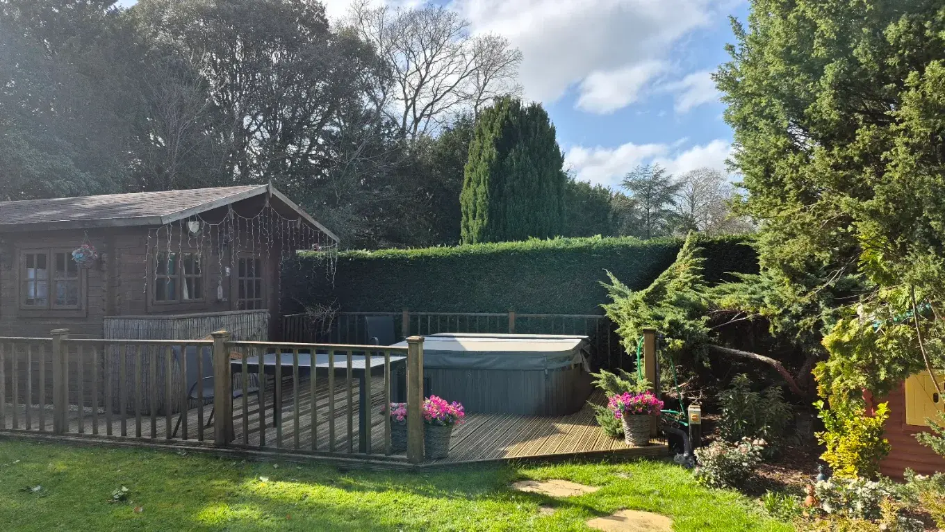 Decked hot tub area beside a timber cabin