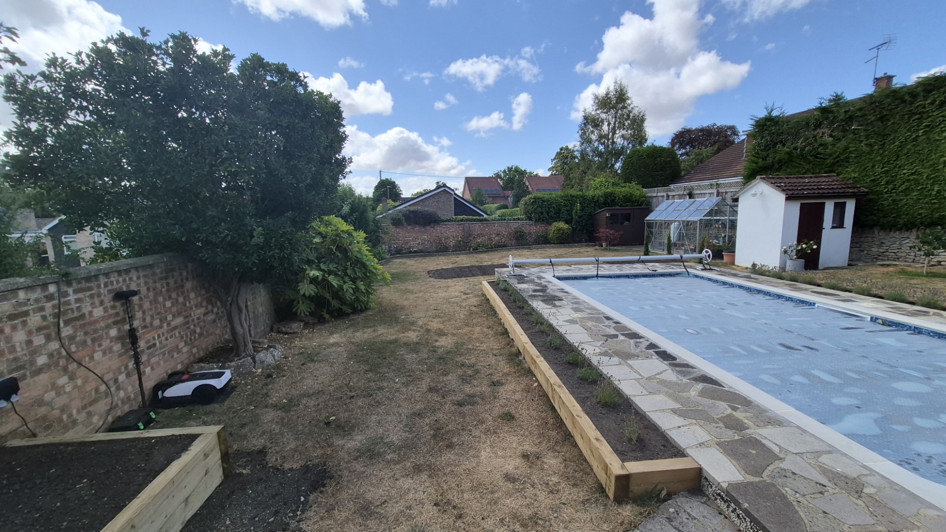 Sleeper edged borders and pathway around a garden swimming pool