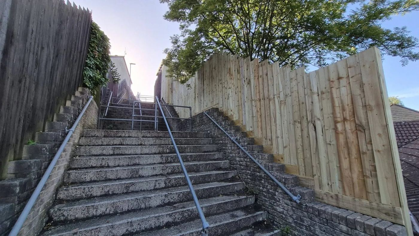 Close board fencing run alongside a steep flight of steps